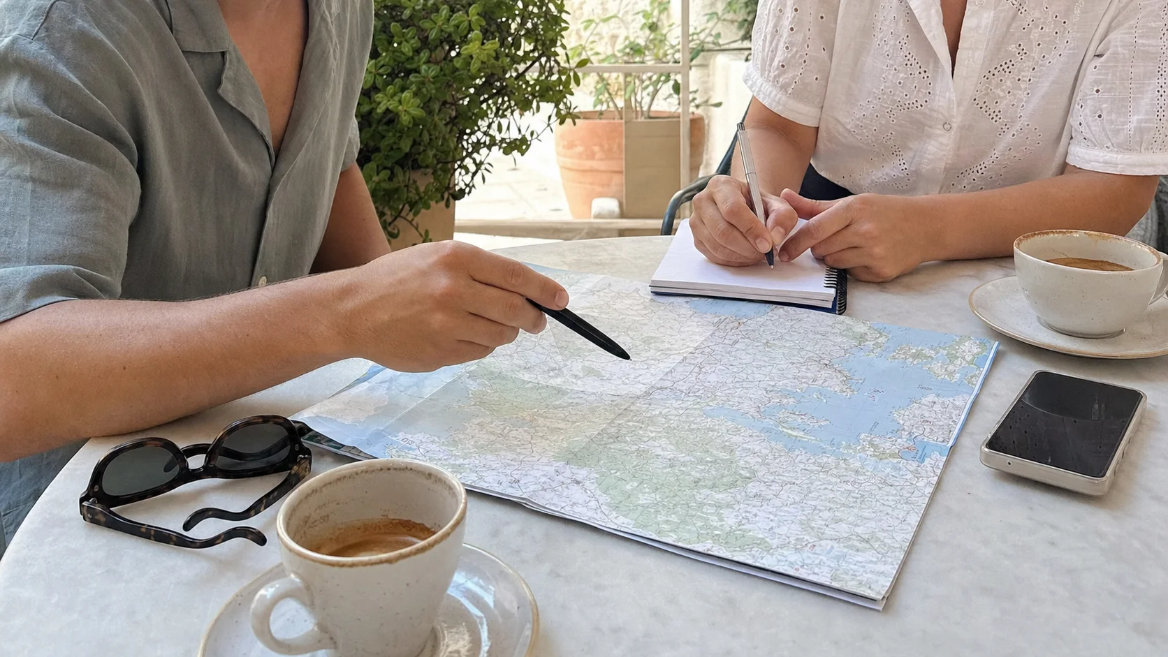Karte, Kaffee und Smartphone bei der Planung eines Spanienurlaubs